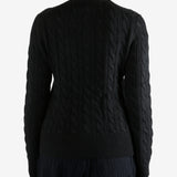 Black knitwear worn by a person, showing the knitwear fit