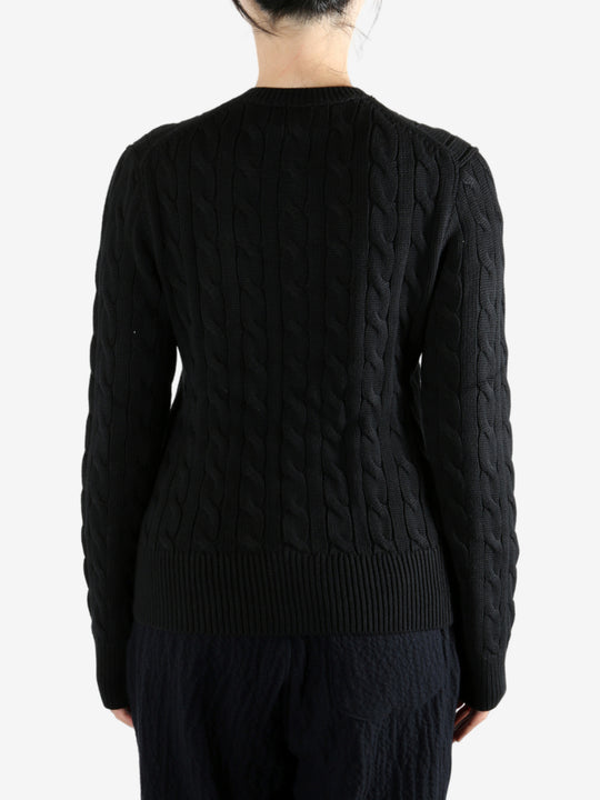Black knitwear worn by a person, showing the knitwear fit