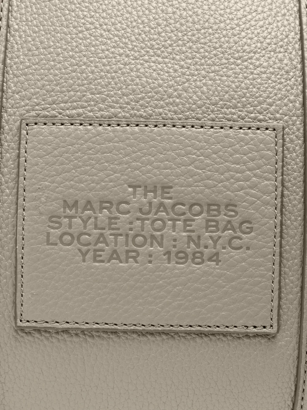 Close up of grey bag, showing brand logo