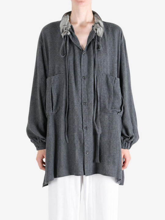 Grey shirt worn by a person, showing the shirt fit