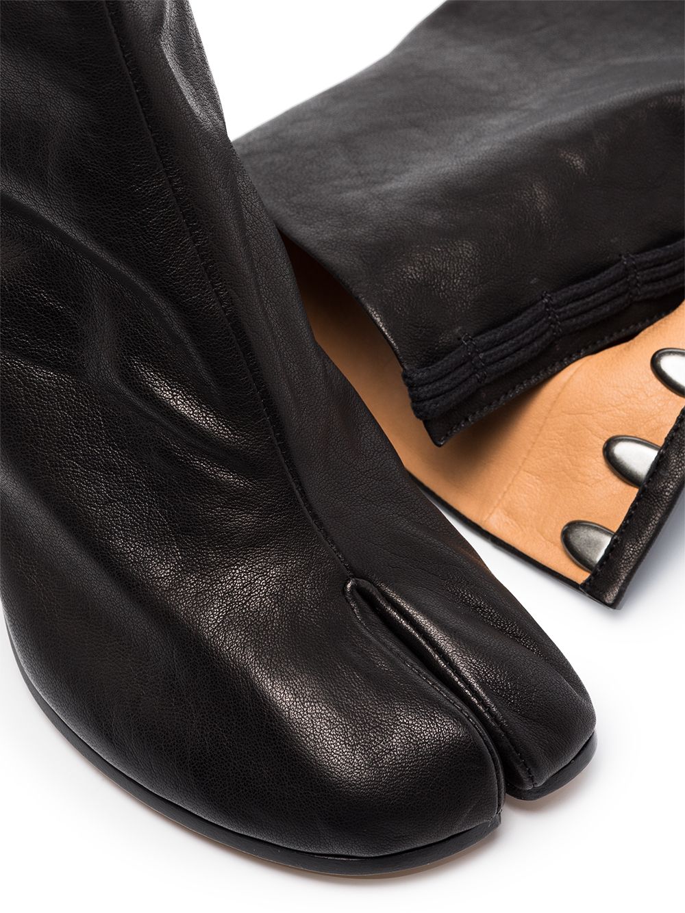 Close up of black boot, showing texture of the leather fabric