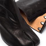 Close up of black boot, showing texture of the leather fabric