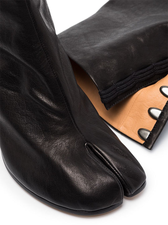 Close up of black boot, showing texture of the leather fabric