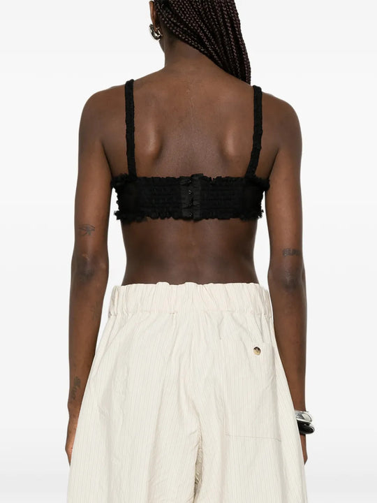 Black top worn by a person, showing the top fit