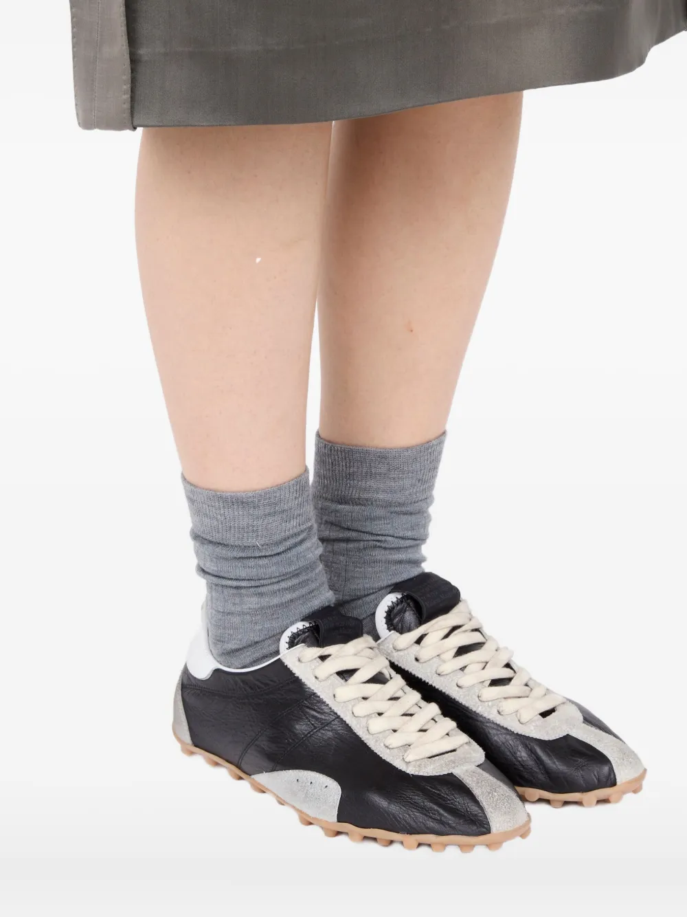 black sneakers worn by a person, showing the sneakers  fit