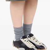 black sneakers worn by a person, showing the sneakers  fit