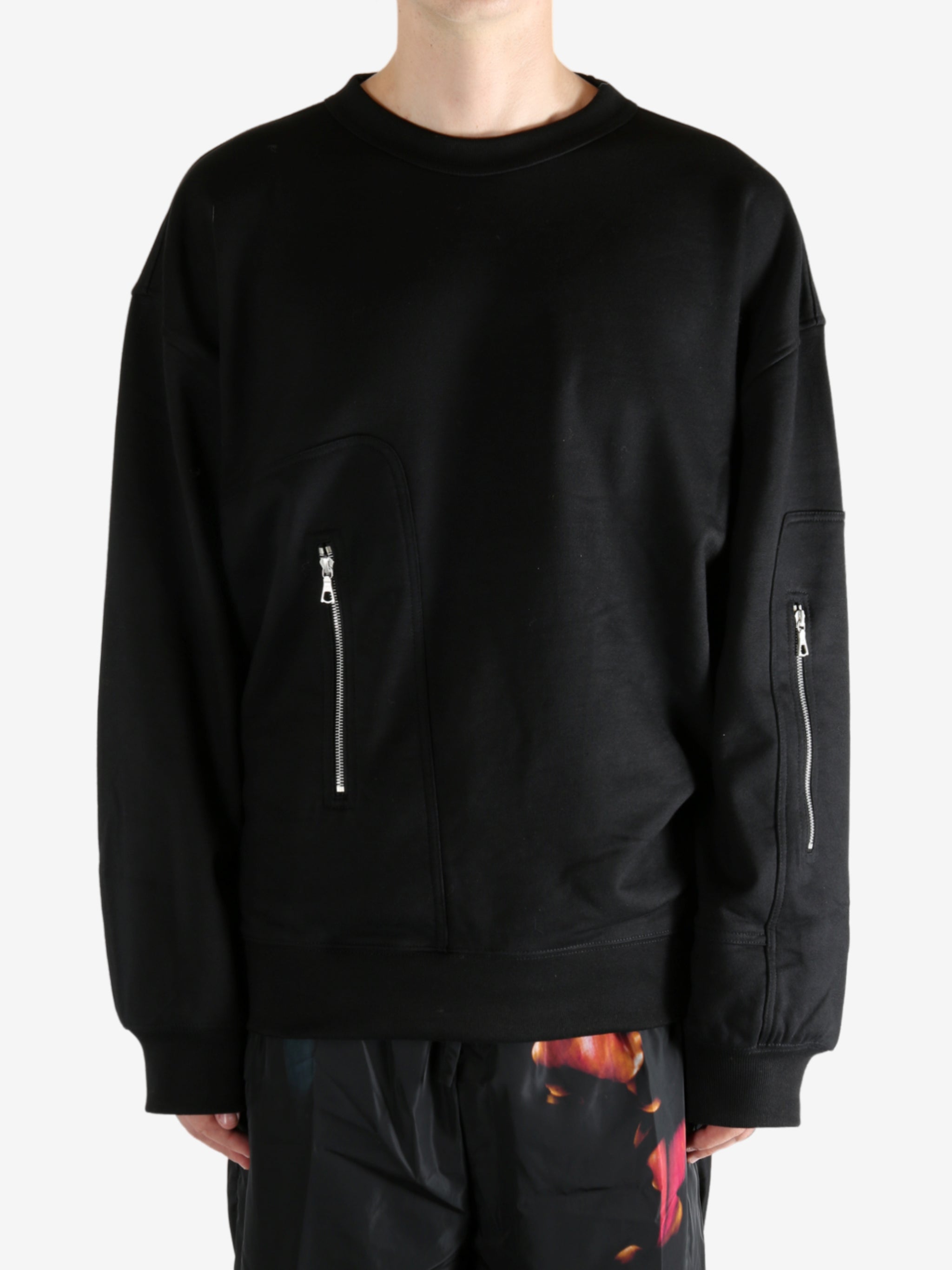 Black sweater worn by a person, showing the sweater's fit