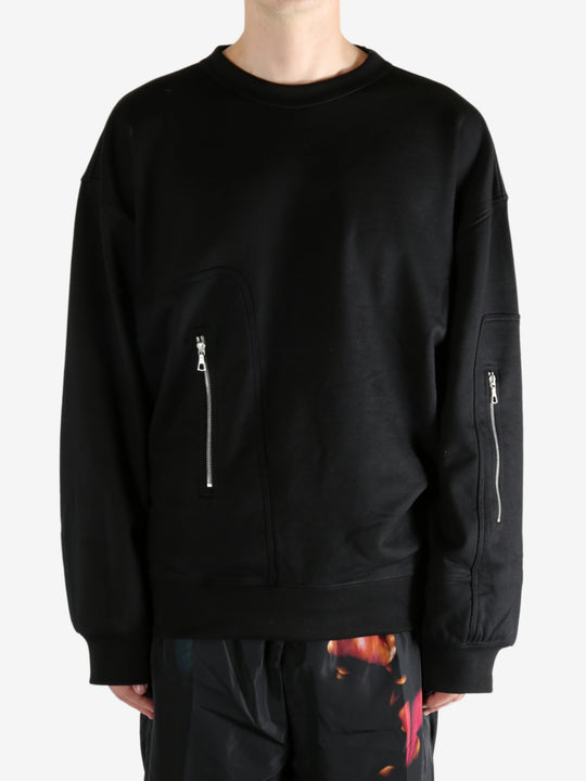 Black sweater worn by a person, showing the sweater's fit