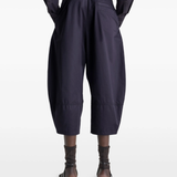 Navy pants worn by a person, showing the pants's fit