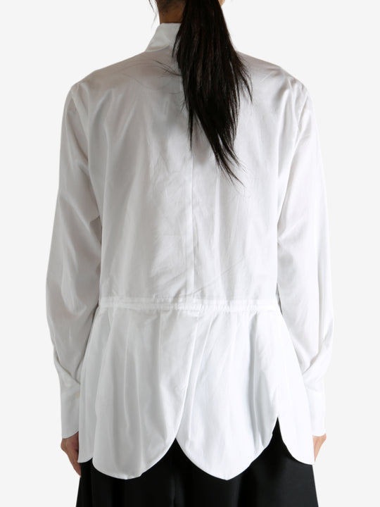 White shirt worn by a person, showing the shirt's fit
