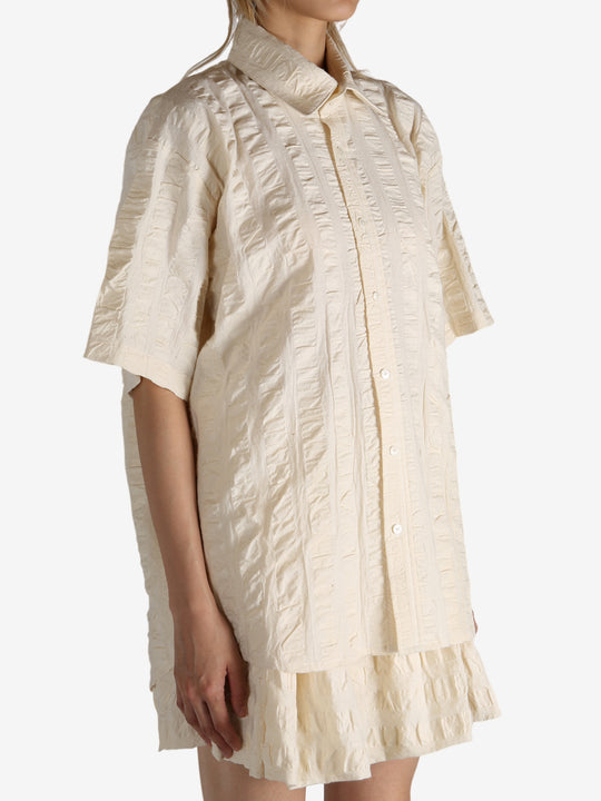 White shirt worn by a person, showing the shirt's fit