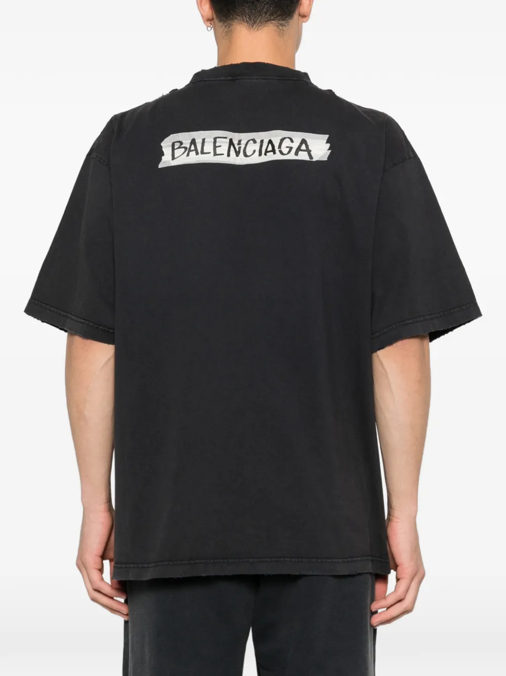 black t-shirt worn by a person, showing the t-shirt fit