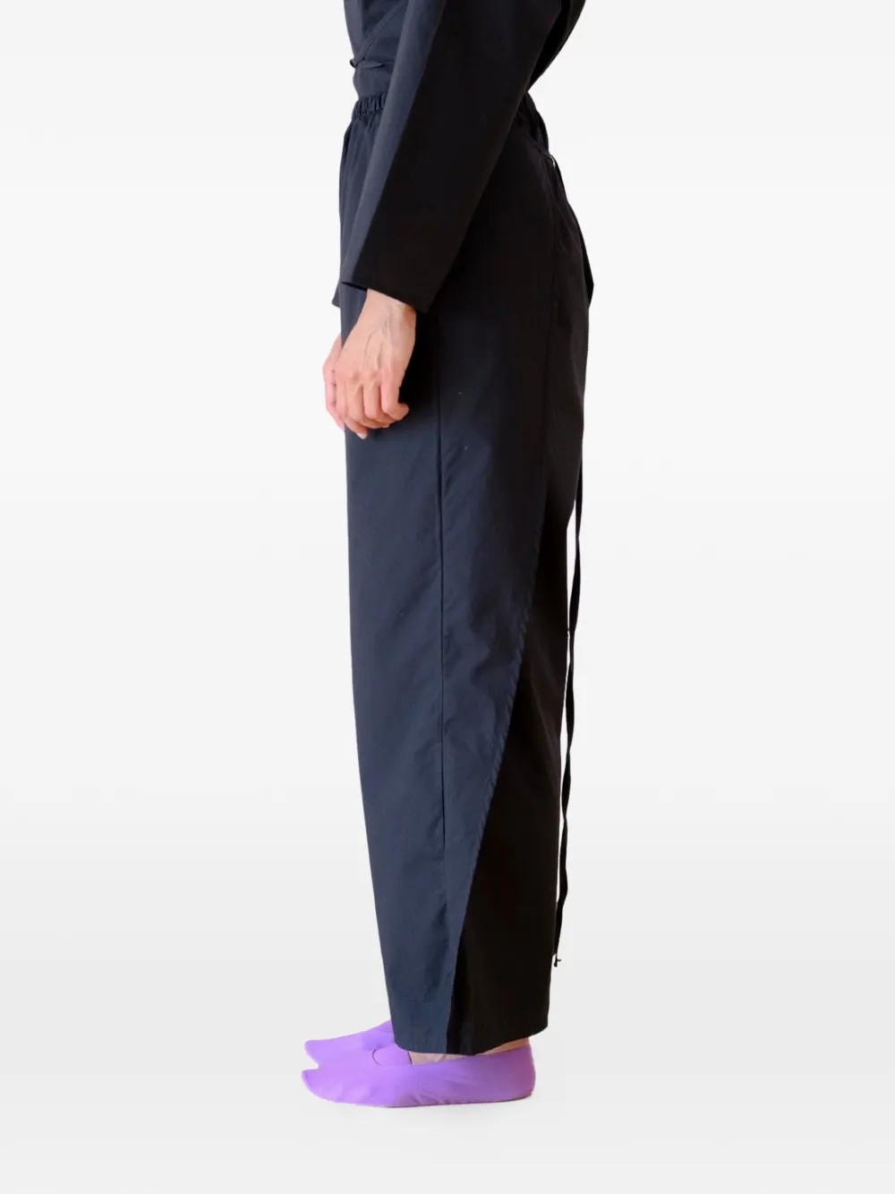 Black pants worn by a person, showing the pants's fit