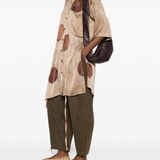 Brown top worn by a person, showing the top's fit