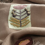 Close up of tan scarves, showing texture of the wool and linen fabric