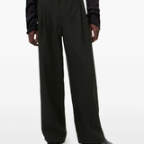 black pants worn by a person, showing the pants  fit