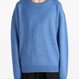 Blue knitwear worn by a person, showing the knitwear fit