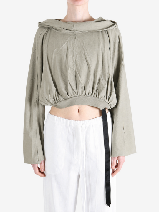 Green top worn by a person, showing the top fit