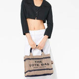 Tan bag carried by a person, showing the bag’s style