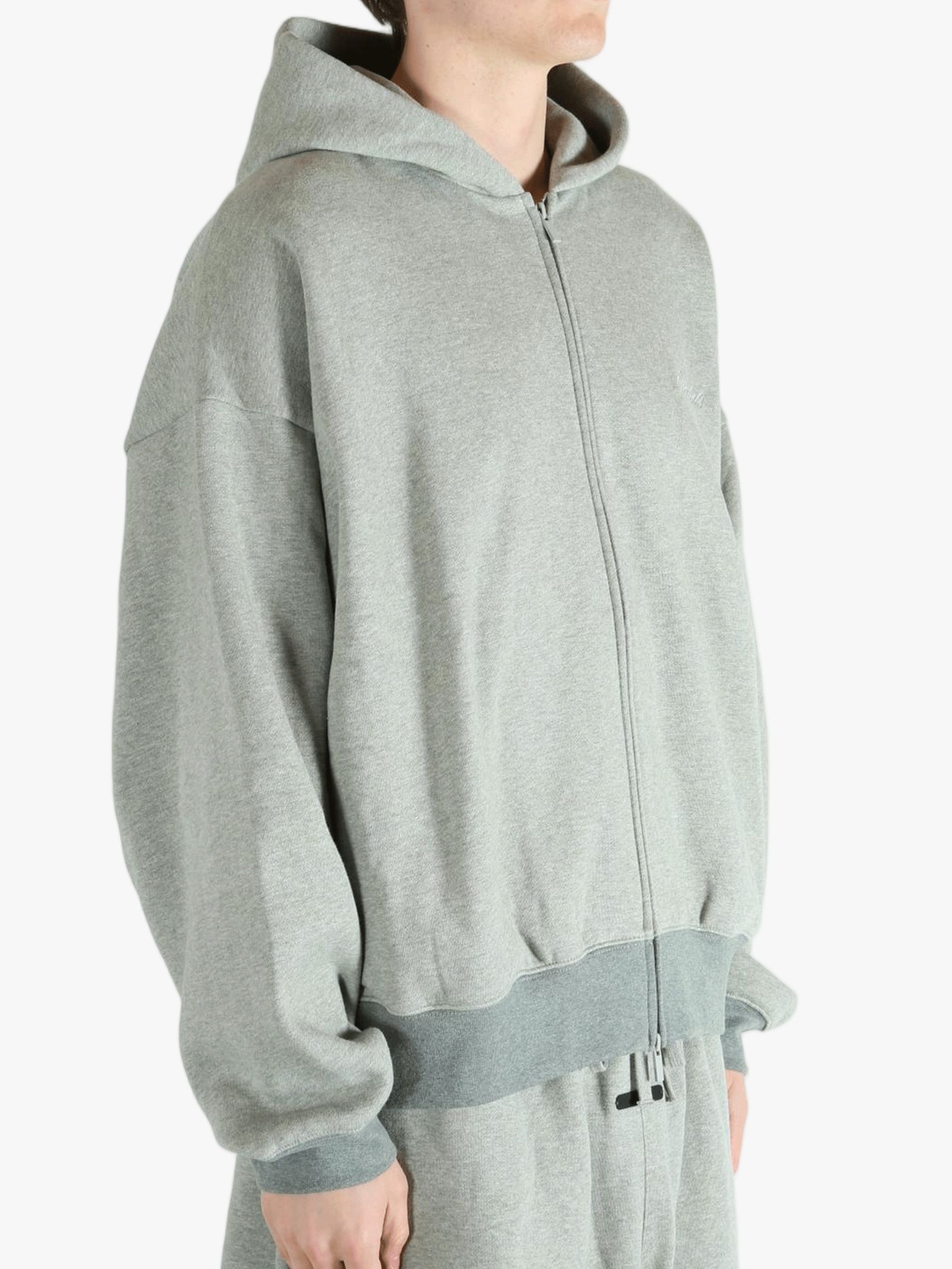 Gray zip-up hoodie worn by a person, showing the hoodie fit
