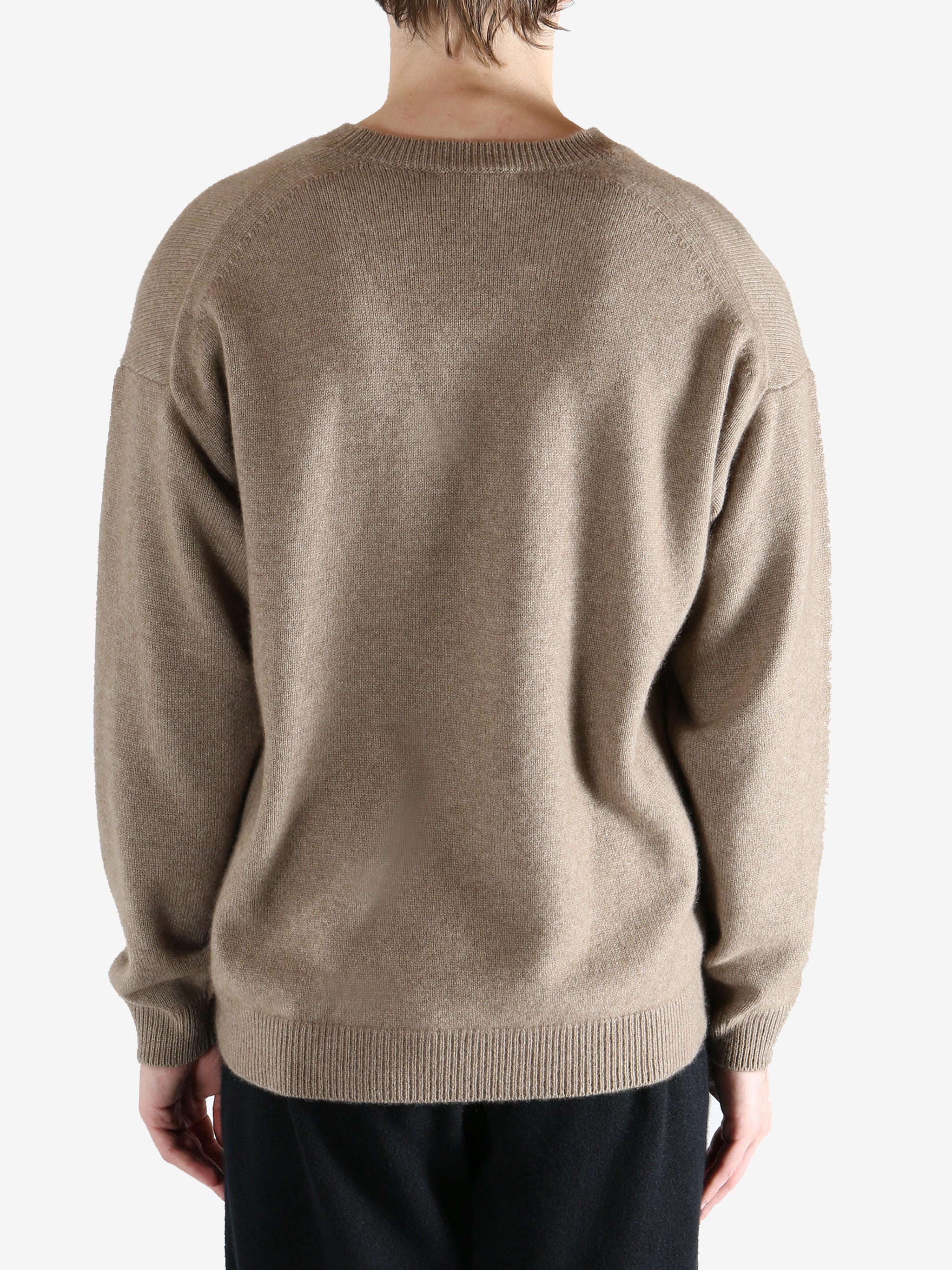 Brown knitwear worn by a person, showing the knitwear's fit