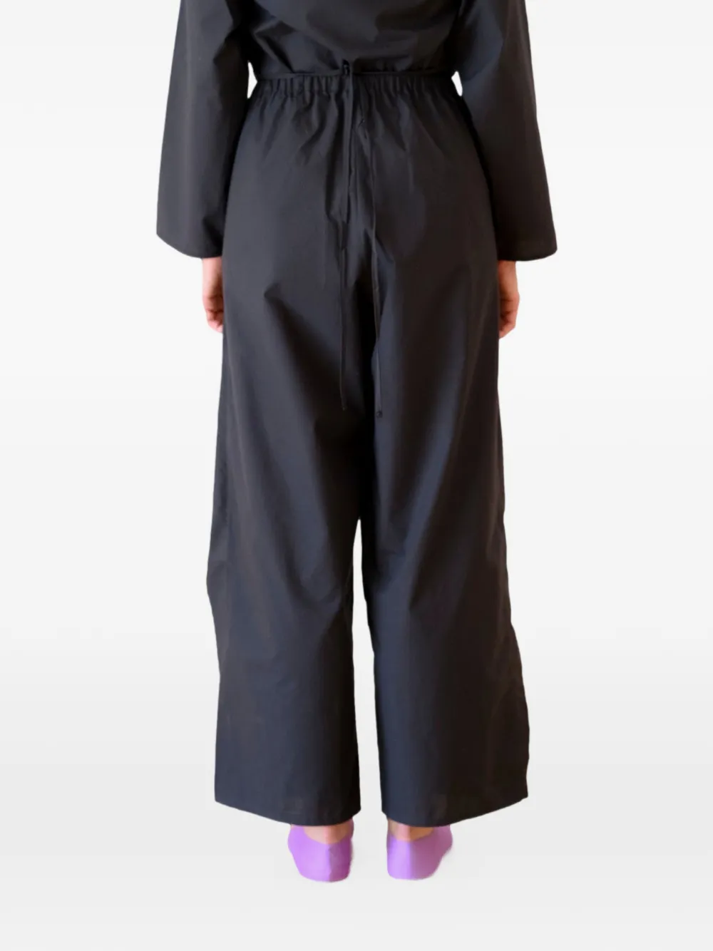 Black pants worn by a person, showing the pants's fit