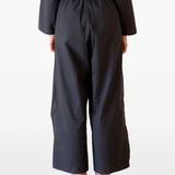 Black pants worn by a person, showing the pants's fit