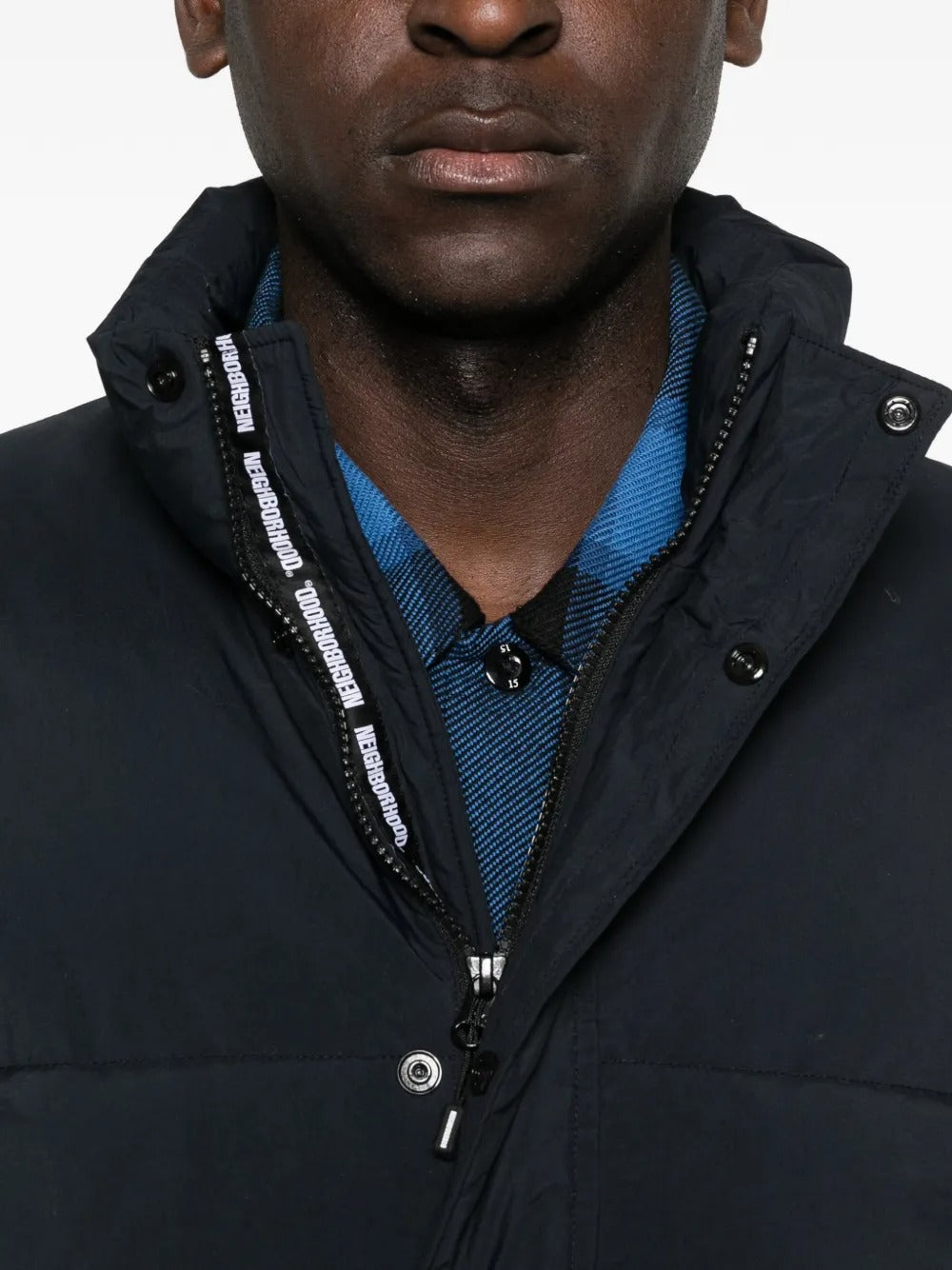 Close up of black jackets, showing texture of the nylon and polyester and down and feather fabric