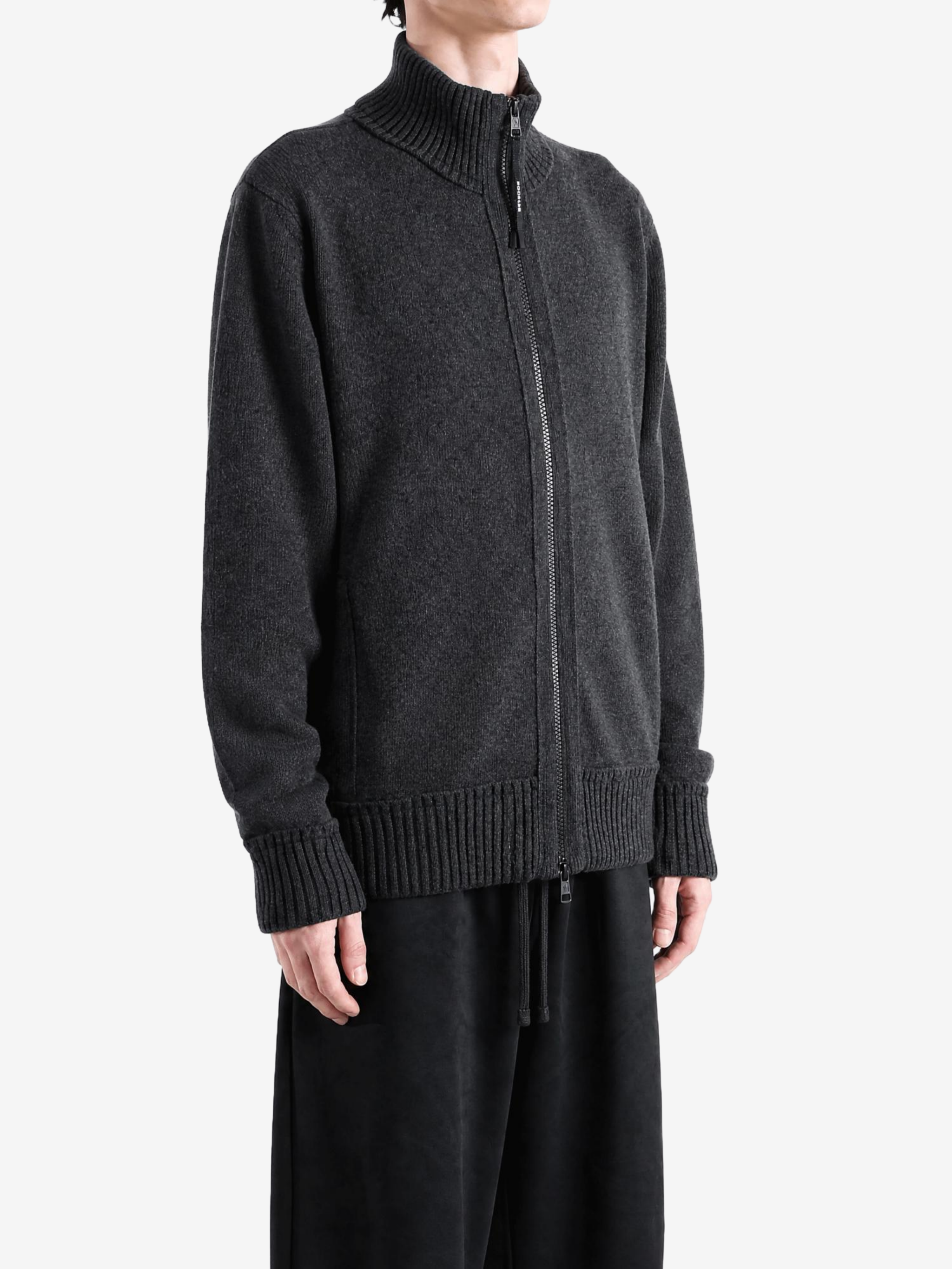 Grey knitwear worn by a person, showing the knitwear fit