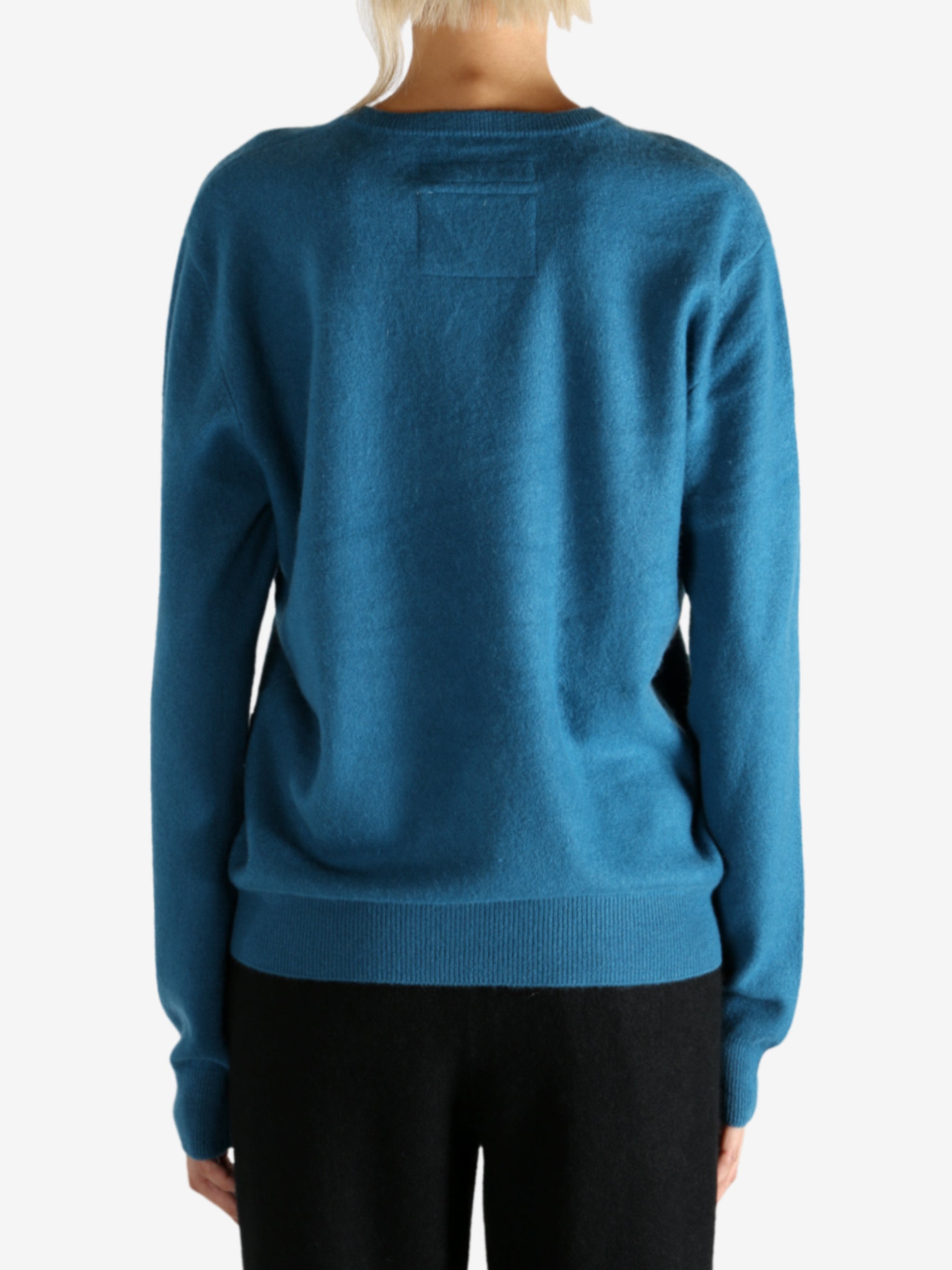 Blue sweater worn by a person, showing the sweater's fit