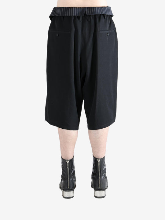 Black pants worn by a person, showing the pants's fit