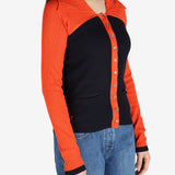Orange top worn by a person, showing the top’s fit