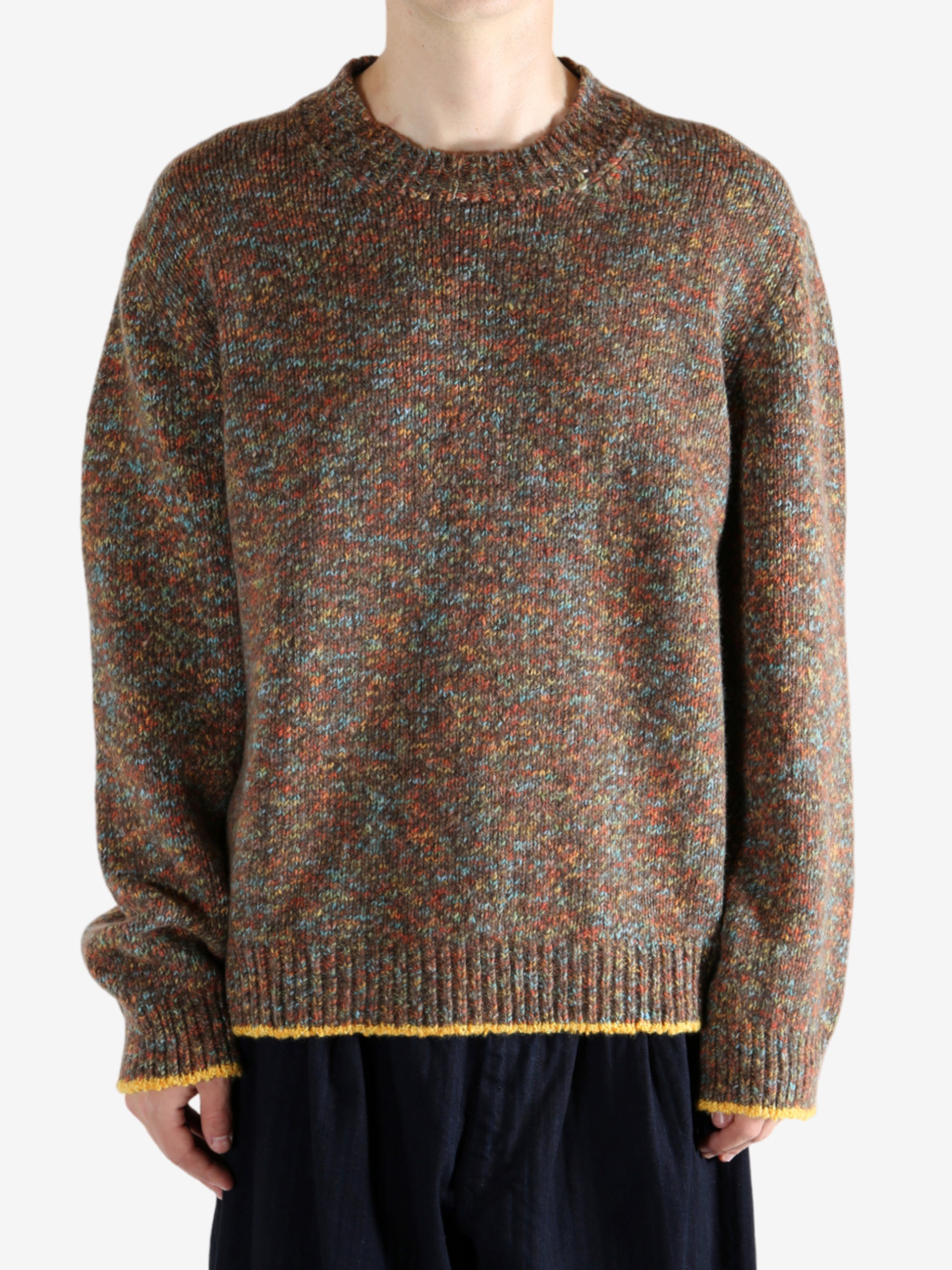 Brown knitwear worn by a person, showing the knitwear's fit
