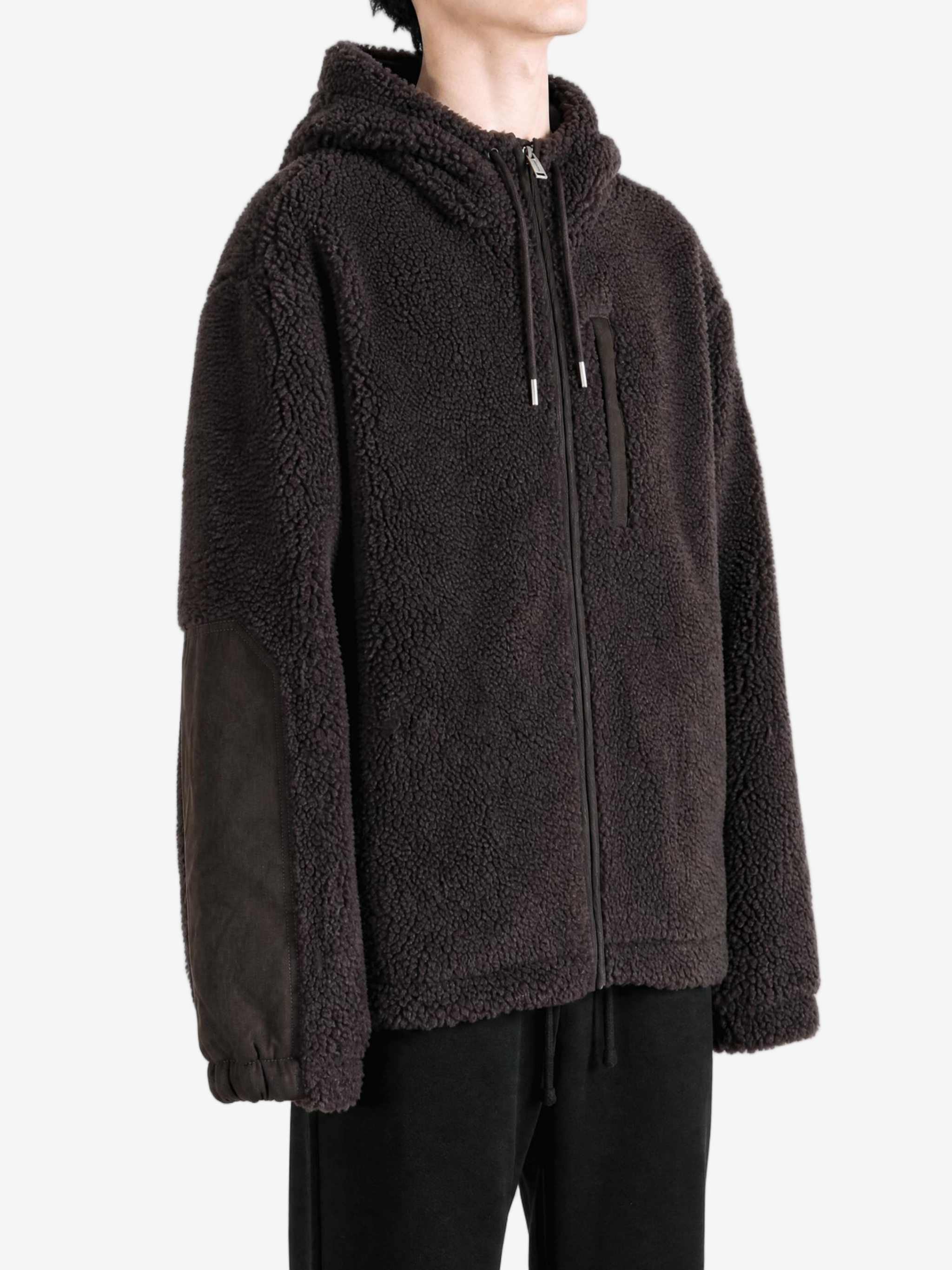 Brown hoodie worn by a person, showing the hoodie fit