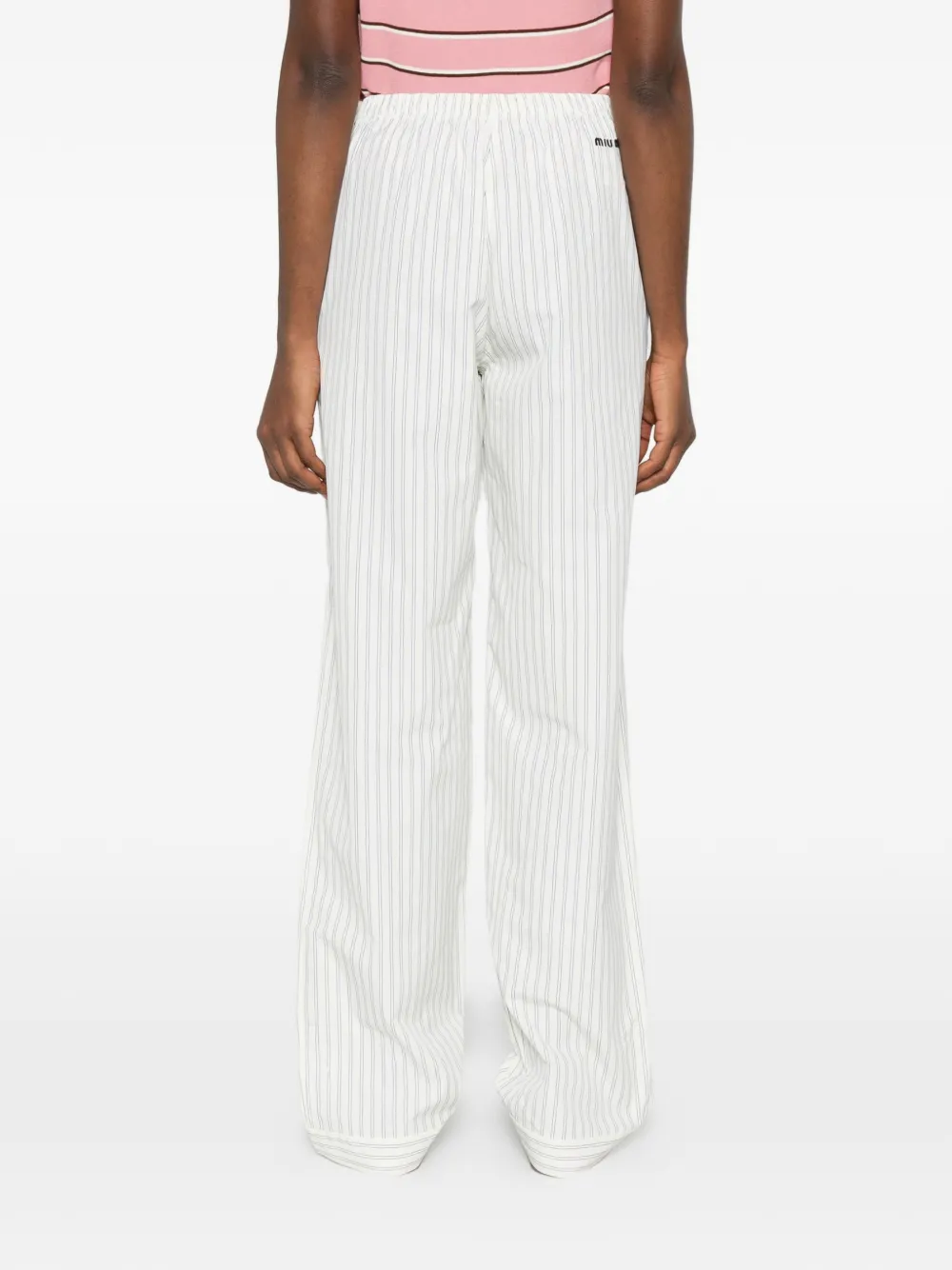 White pants worn by a person, showing the pants fit