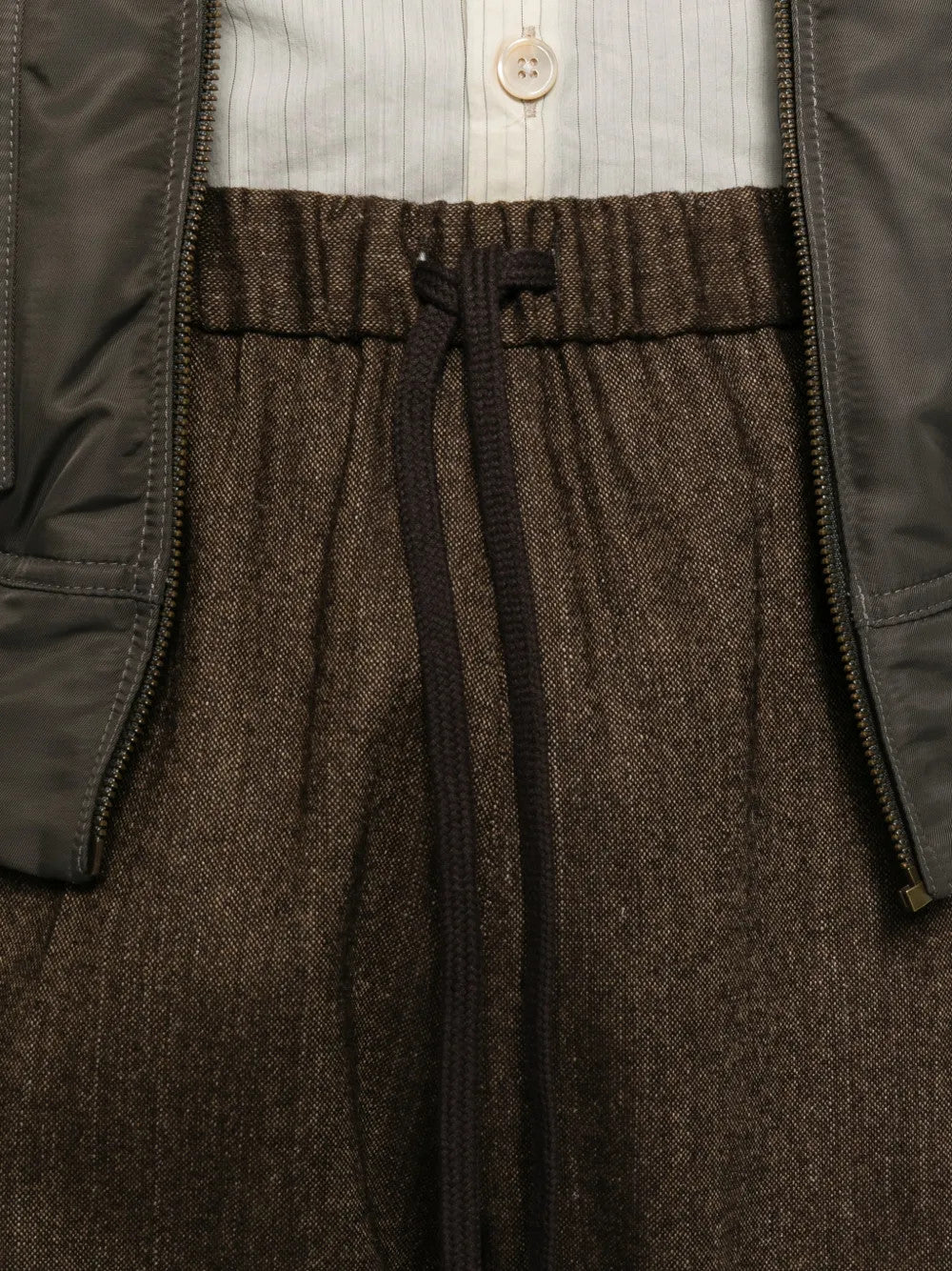 Close up of Brown pants, showing texture of the 57% wool/ 21% polyester/ 12% polyamide/ 8% linen/ 2% other fabric