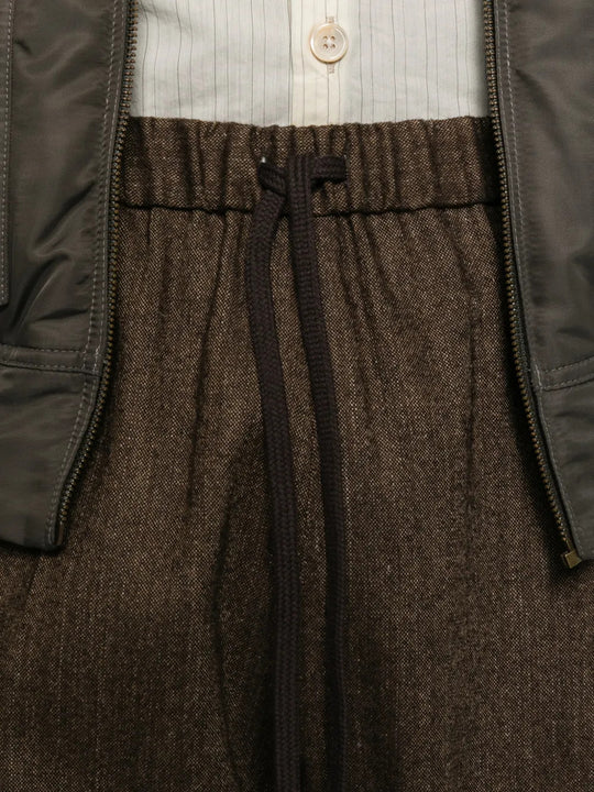 Close up of Brown pants, showing texture of the 57% wool/ 21% polyester/ 12% polyamide/ 8% linen/ 2% other fabric