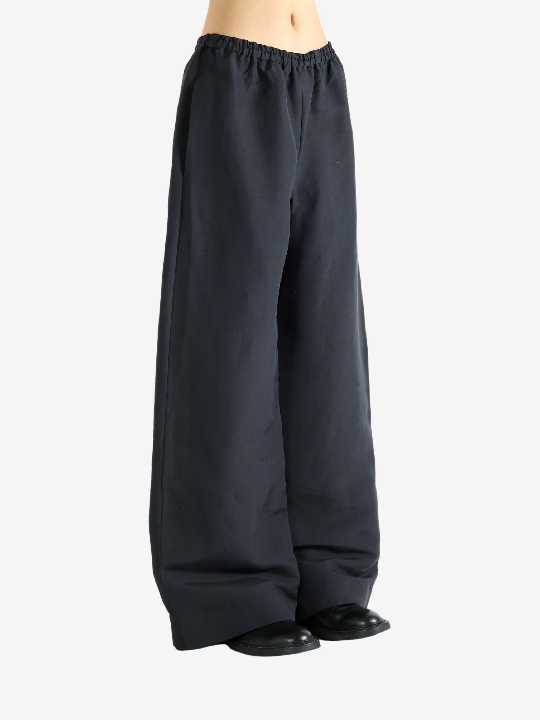 Black pants worn by a person, showing the pants' fit