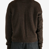 Brown knitwear worn by a person, showing the knitwear's fit