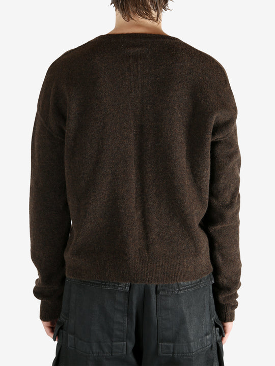 Brown knitwear worn by a person, showing the knitwear's fit