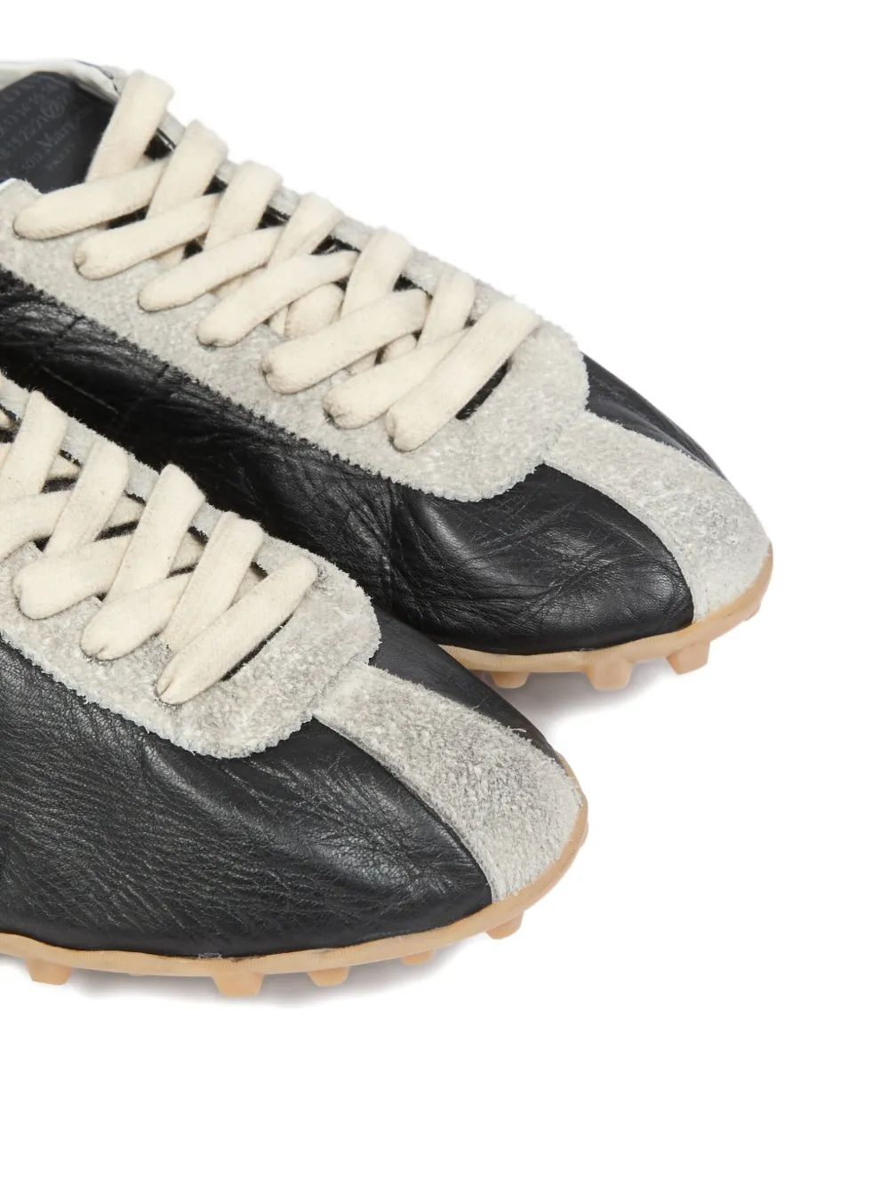 close up of black sneakers, showing texture of the goat leather fabric