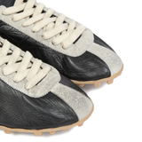 close up of black sneakers, showing texture of the goat leather fabric