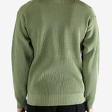 Green knitwear worn by a person, showing the knitwear's fit