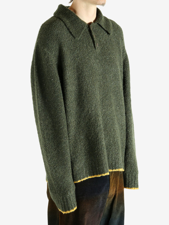 Green knitwear worn by a person, showing the knitwear's fit
