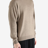 Brown knitwear worn by a person, showing the knitwear's fit