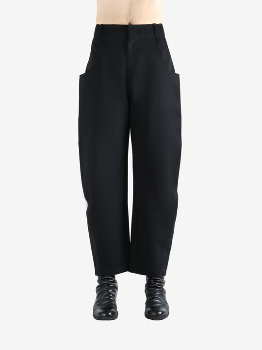 Black pants worn by a person, showing the pants' fit