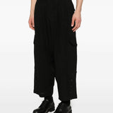 Black pants worn by a person, showing the pants's fit