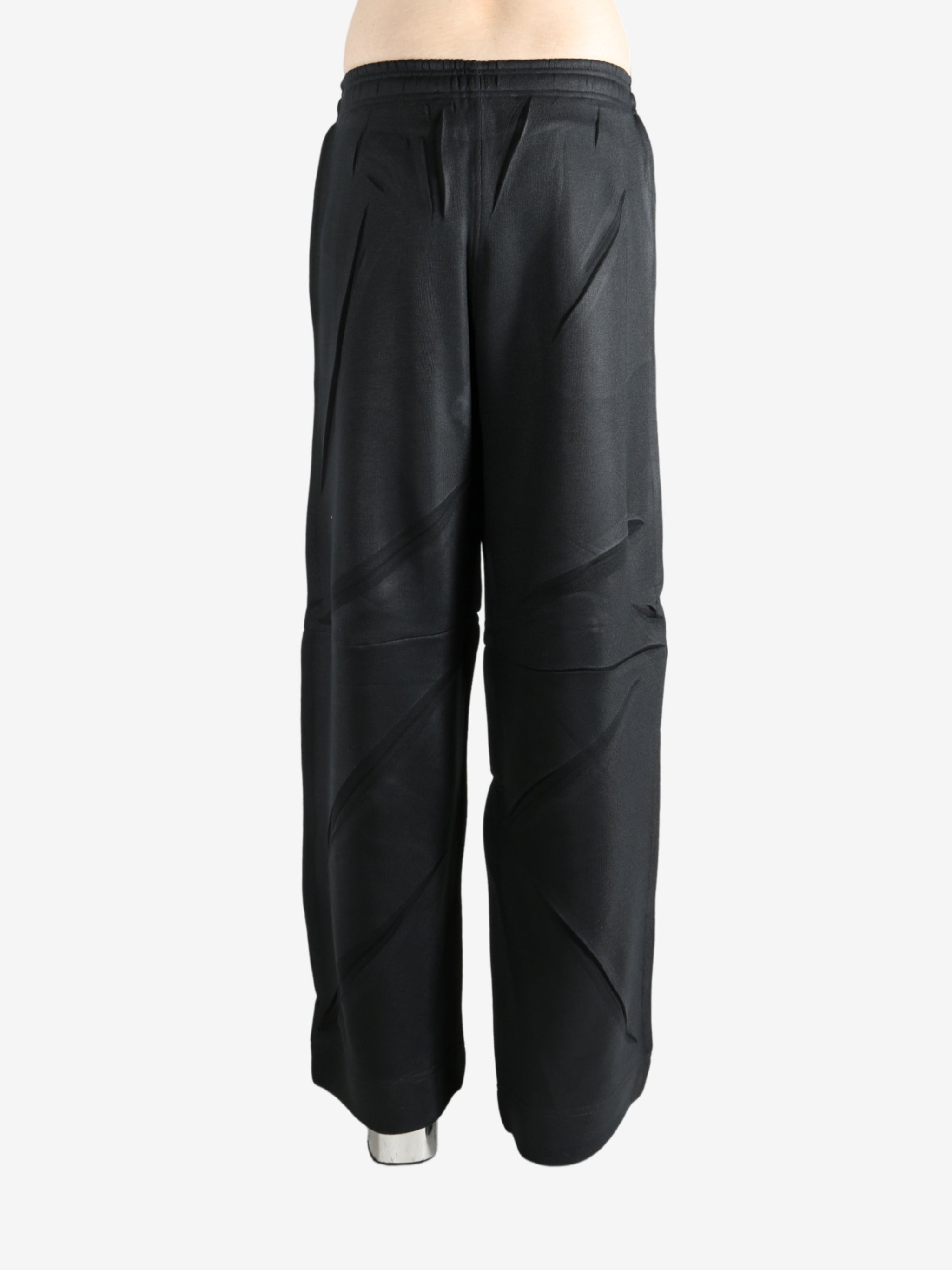 Black pants worn by a person, showing the pants' fit