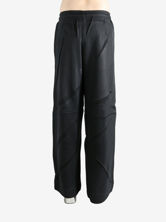 Black pants worn by a person, showing the pants' fit