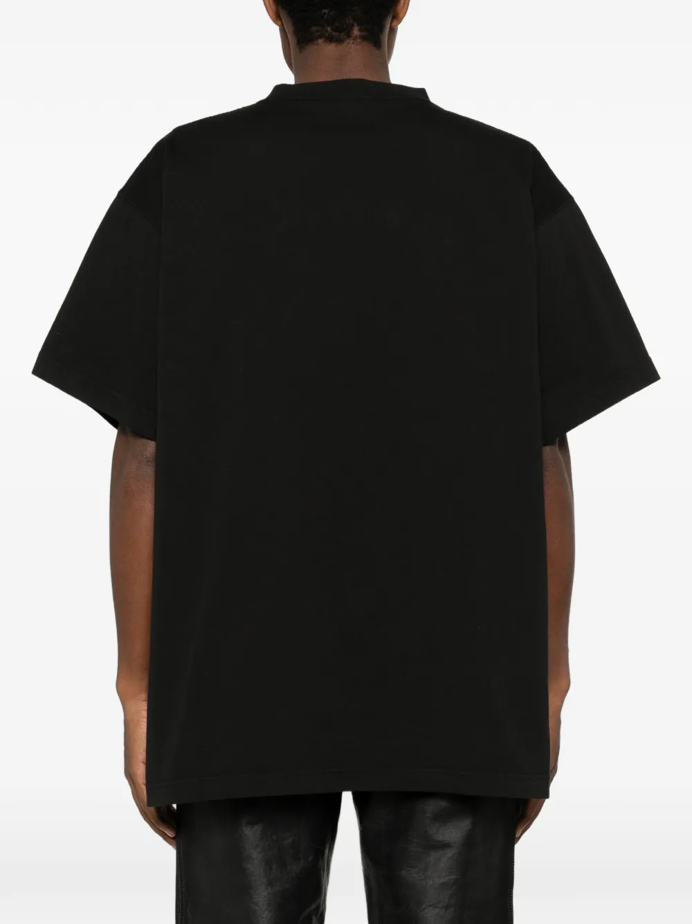 Black T-shirt  worn by a person, showing the  shirt's fit